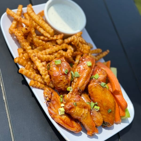 A plate of LOCAL's chicken wings, crinkle-cut fries, and a side of ranch dressing.